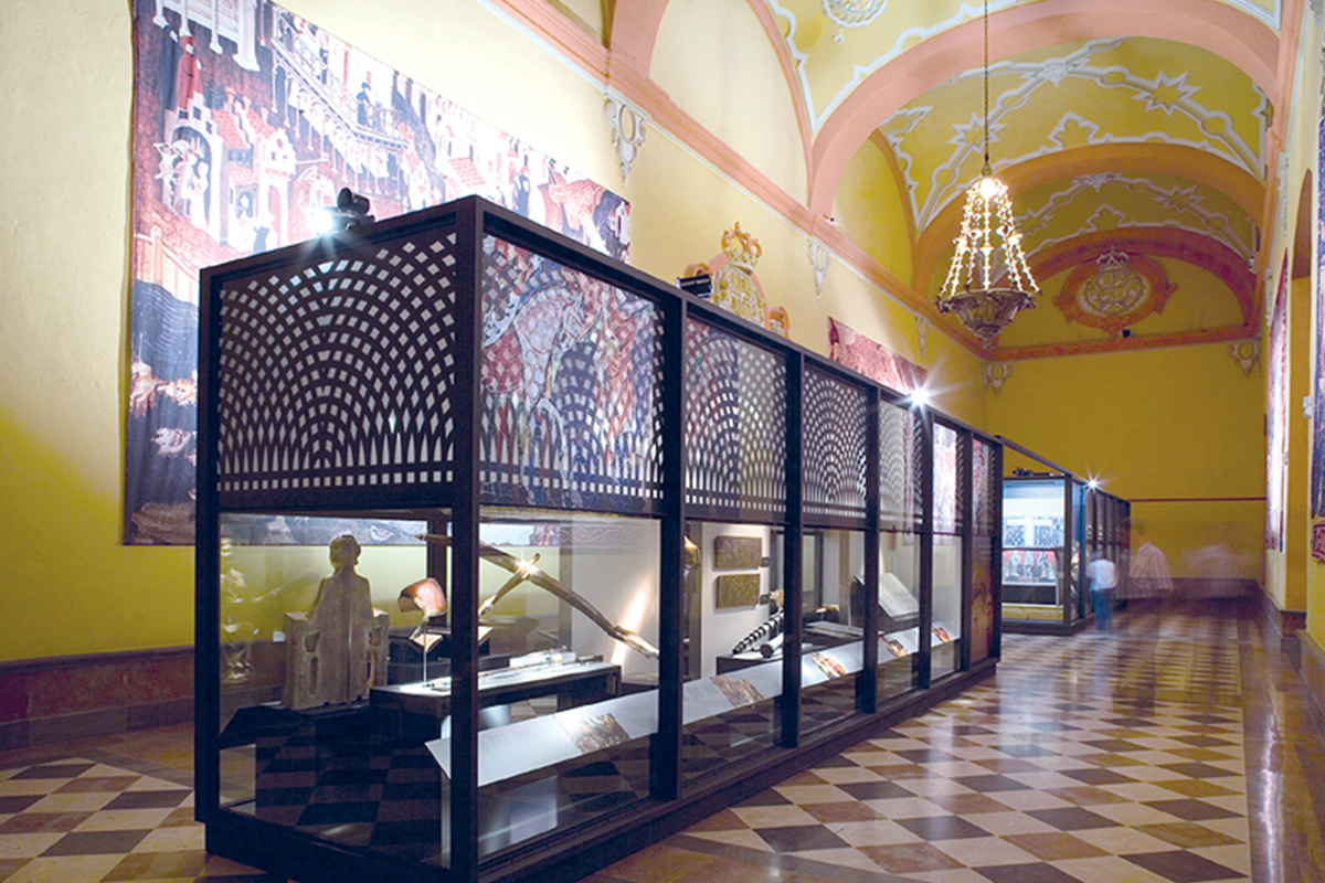 Central display case in the Tapestry Hall. Among the pieces on display we could find a Nasrid crossbow originating from the Alpujarra of Granada, shaped by two pieces.