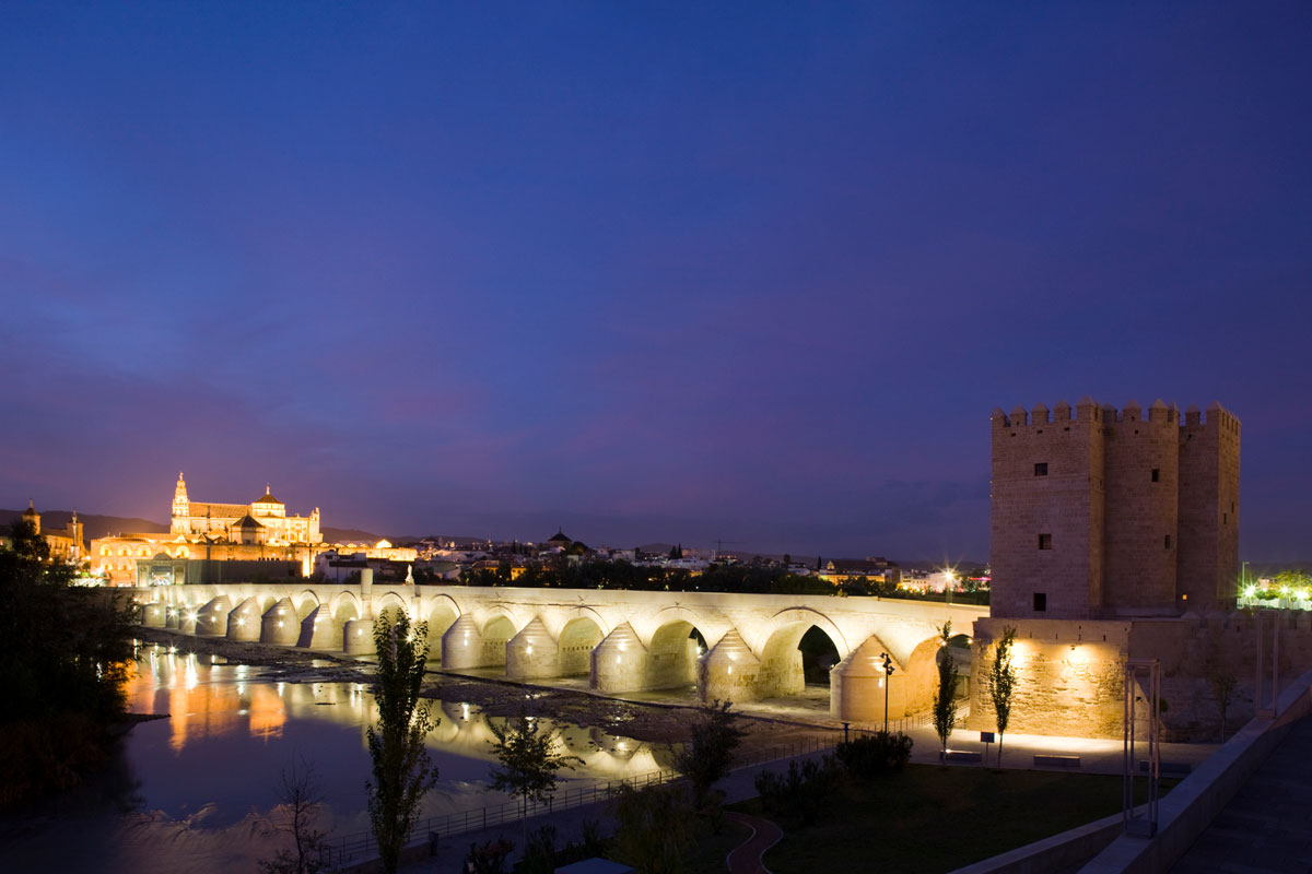 Vista nocturna de Córdoba con la Torre de la Calahorra en primer plano y la Mezquita-Catedral al fondo.