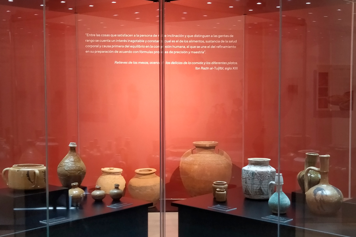 Tableware from al-Andalus in the foreground, and diverse types of liquid storage jars in the background.